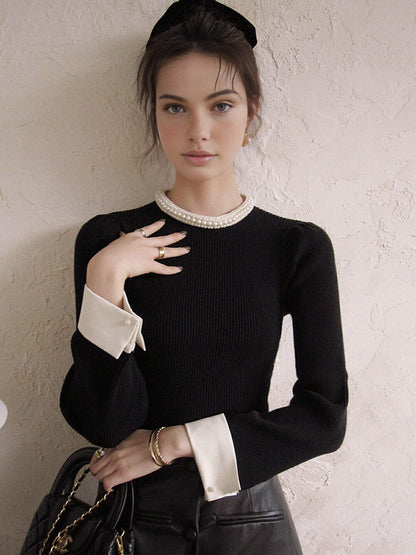 Sweter o kontrastowym kroju z perłowymi detalami