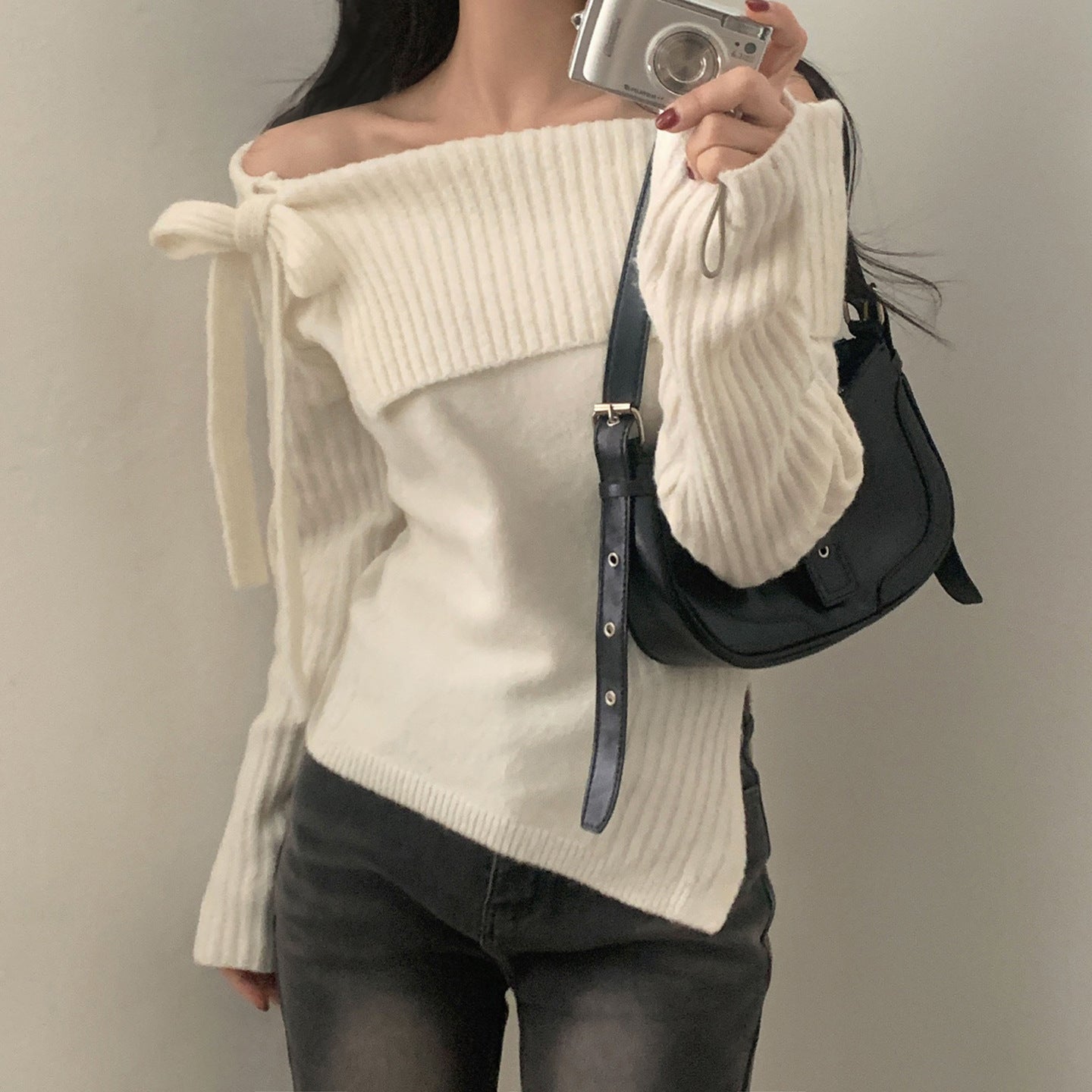 Sweter z odkrytymi ramionami, ściągaczem, kokardą i rozcięciem.